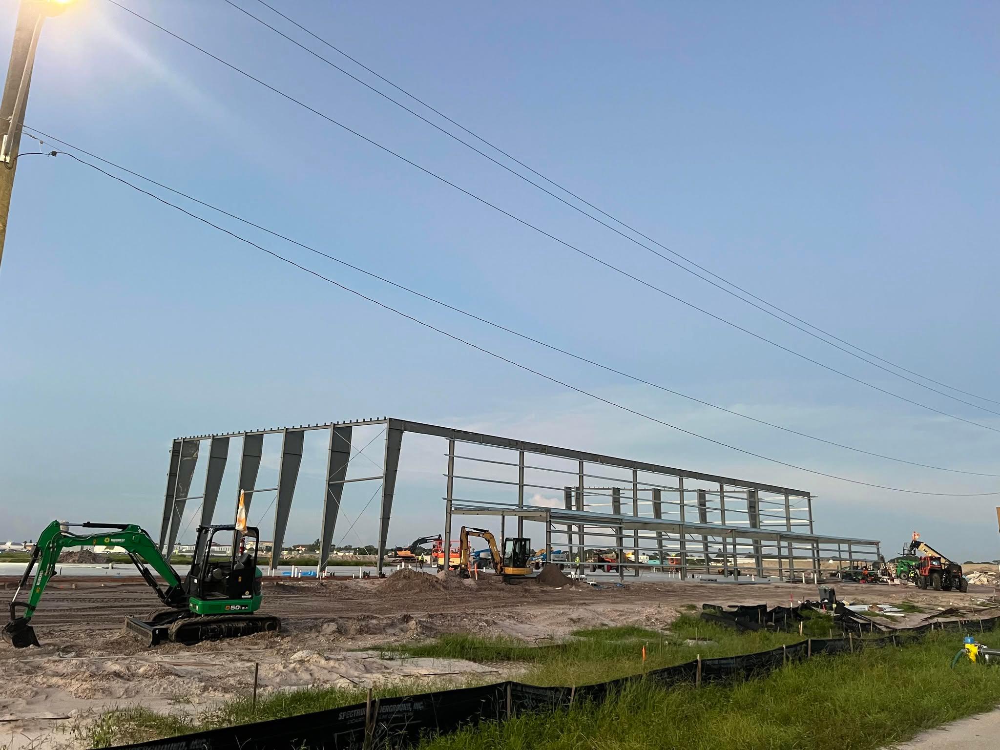 Long-span steel warehouse frame with purlins installed, photographed down the length of the building