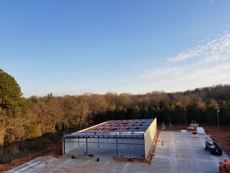 Completed metal building shell at dusk with roof and wall panels installed, sealed and ready for interior trades