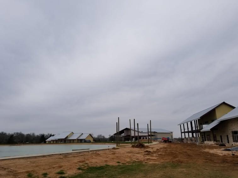 Overview of a working site with several metal structures at different stages of erection across open ground